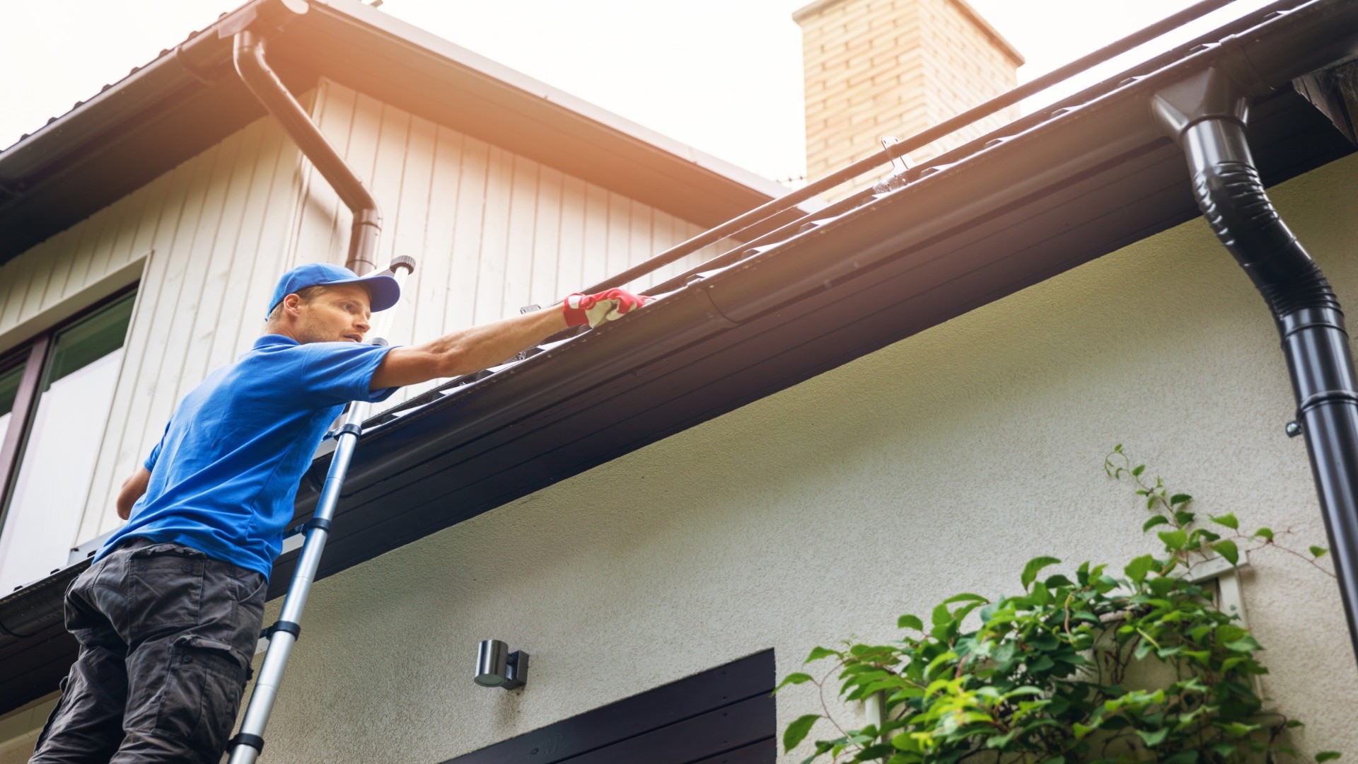 Plumber performing gutter maintenance