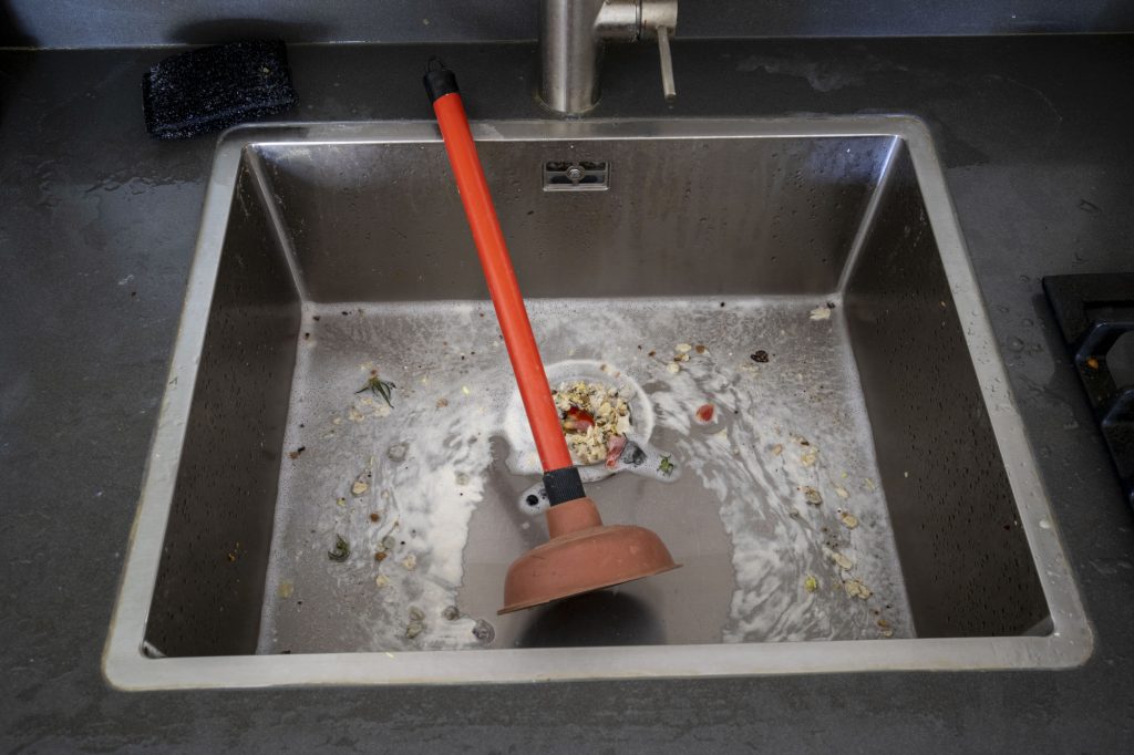 Overflowing kitchen sink, clogged drain.